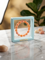 The bracelet features smooth oval beads with unique orange and cream swirls, creating an elegant and minimalist fashion accessory suitable for men and women.