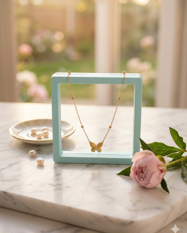 A flat lay view of a gold butterfly pendant necklace displayed against a smooth, solid light gray background, as seen in Butterfly shape pendant chain.